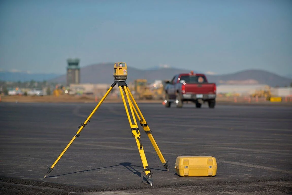Survey instrument set up on a paved construction site